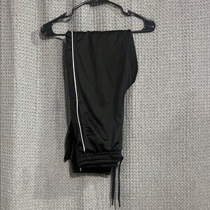 Black Track Pants with White Stripe, pockets and zippered bottoms.